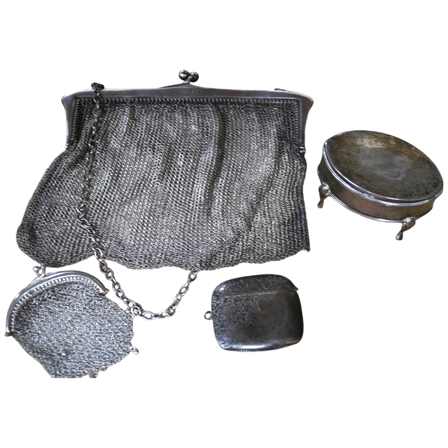 A George V silver trinket box, 68mm, a silver vesta case and two silver mesh evening bags. Condition - poor to fair